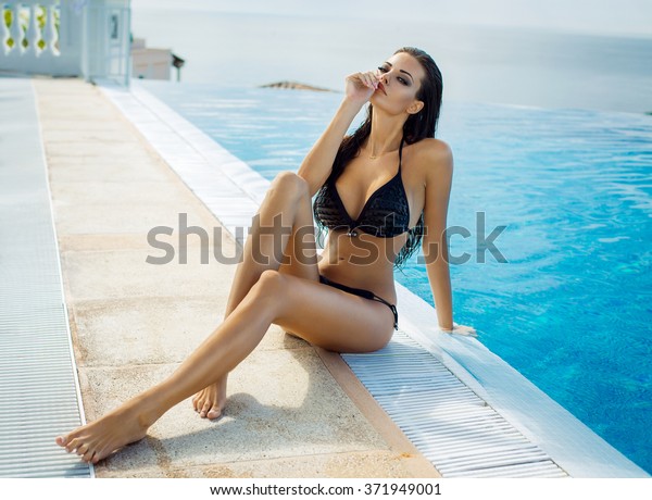夏の景色の中 プールのそばで黒いビキニを着た美しい女性 の写真素材 今すぐ編集