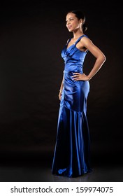 Beautiful Woman Wearing Blue Evening Dress On Black Background