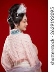 Beautiful woman wearing Chinese Ming Dynasty Hanfu with hairpin and flower ornaments on red background