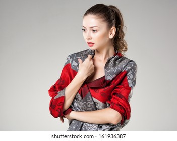 beautiful woman wearing colorful kashmir scarf isolated on grey - landscape, copy-space