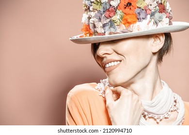 Beautiful woman wearing floral hat over pale brown background	 - Shutterstock ID 2120994710