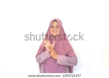 Beautiful woman wearing hijab with letter N finger sign language and friendly expression. Selective focus. Foto stock © 