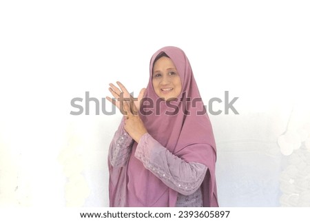 Beautiful woman wearing hijab with letter N finger sign language and friendly expression. Selective focus. Foto stock © 