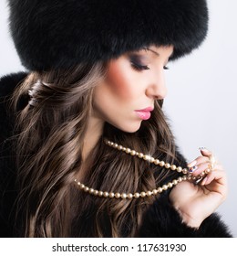 Beautiful woman wearing luxury fur coat and hat