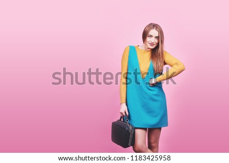 Beautiful woman wearing nice clothes, handbag posing on pink background. Fashion spring photo.