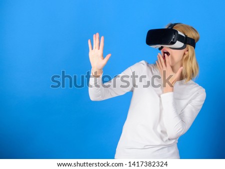 Beautiful woman wearing virtual reality goggles in studio. Confident young woman adjusting her virtual reality headset and smiling. Excited smiling businesswoman wearing virtual reality glasses