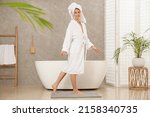 Beautiful woman wearing white robe in bathroom