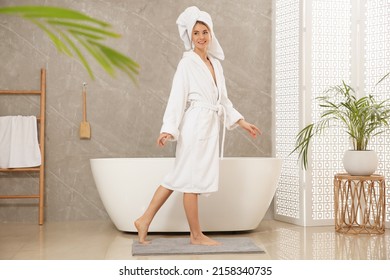 Mujer hermosa con toga blanca en el baño