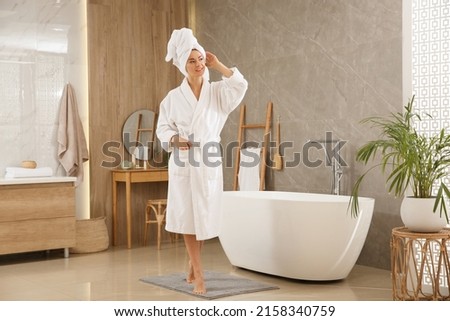 Beautiful woman wearing white robe in bathroom