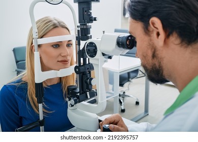 Beautiful Woman While Eye Exam With Binocular Slit-lamp At Ophthalmology Clinic With Experienced Male Optometrist