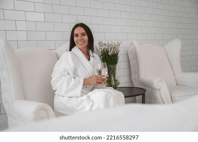 Beautiful Woman In White Bathrobe Drink Water During Medical Procedure In Beauty Clinic