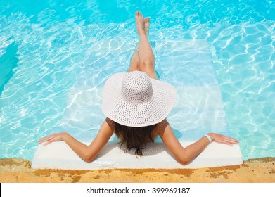 Beautiful Woman White Hat And Bikini Lying In A Pool