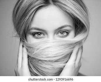 A beautiful woman who covered her mouth with hair, focus on the eyes.
