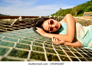 A beautiful woman who enjoys lying and resting On the terrace stretching out into the sea - Powered by Shutterstock