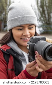 Beautiful Woman Who Is Wearing A Woolen Cap Is Holding A Camera And Taking Photo Of Rural Scene, Lifestyle And Hobbies With Technology, Photography Beauty