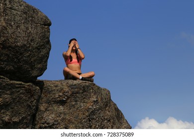 Beautiful Woman Wipes Sweat From Her Brow After Hiking To The Top Of A Rocky Mountain Peak.