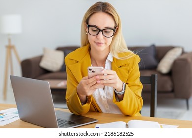 Beautiful woman working using computer laptop and mobile phone, concentrated sitting in modern office, online remote work, young entrepreneur, small business owner - Shutterstock ID 2186182525