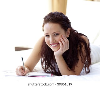 Beautiful Woman Writing Notes Lying In Bed