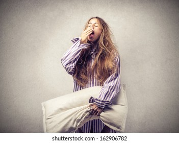 Beautiful Woman Yawning With A Pillow In Hand