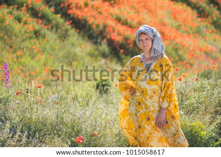 Beautiful woman in yellow dress in the meadow field of very hot weather.