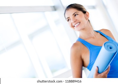 Beautiful Woman With A Yoga Mat At The Gym