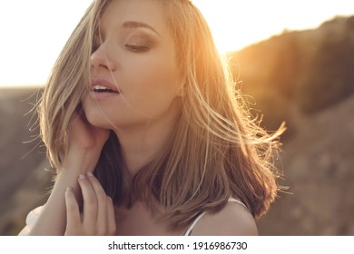 Beautiful woman. Young girl with rays of sunset bill. Portrait.