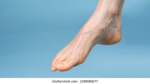 Beautiful woman's bare feet against a blue background. - Shutterstock ID 2188580677
