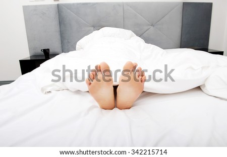 Beautiful woman's bare feet in bedroom.