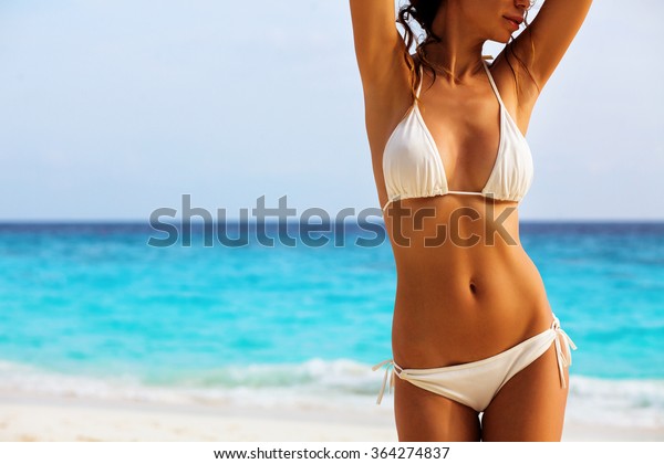 ビーチ背景にセクシービキニの美しい女性の体 の写真素材 今すぐ編集