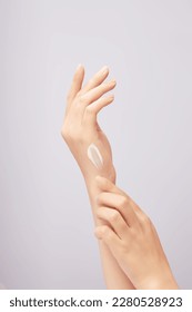 Beautiful woman's hand applying cream on back of hand, applying lotion on skin. Close-up in light background. Skin care concept, try anti-irritant cream - Shutterstock ID 2280528923