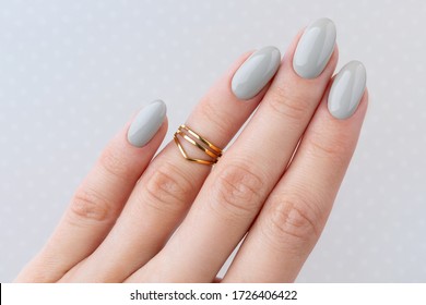 Hermosas mujeres con manicura cerca de fondo de punto de polka. Esmalte de uñas gris. El concepto de salón de belleza. 