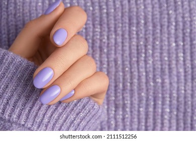 Beautiful womans hand in sweeter with purple fashionable spring nail design
