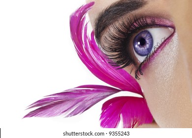 Beautiful woman`s open eye. Pink feathers on background. - Powered by Shutterstock