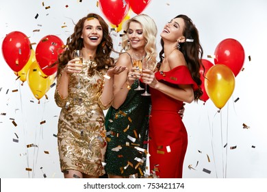 Beautiful Women Celebrating New Year, Having Fun At Party. Portrait Of Happy Smiling Girls In Stylish Glamorous Dresses With Champagne Glasses At Fashion Party. High Resolution.