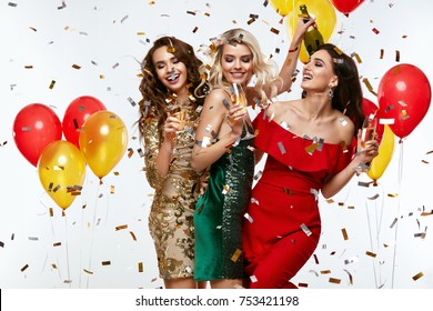 Beautiful Women Celebrating New Year, Having Fun At Party. Portrait Of Happy Smiling Girls In Stylish Glamorous Dresses With Champagne Glasses At Fashion Party. High Resolution.