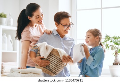 Beautiful Women And Child Girl Little Helper Are Having Fun And Smiling While Doing Laundry At Home.