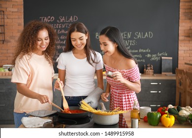 Beautiful Women Cooking Together In Kitchen