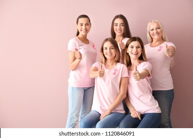Beautiful women of different ages with pink ribbons showing thumbs-up gesture on color background. Breast cancer concept