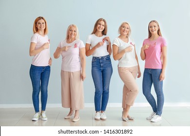 Beautiful women of different ages with pink ribbons near light wall. Breast cancer concept - Powered by Shutterstock