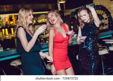 Beautiful Women Drink Cocktails And Dance In The Bar.