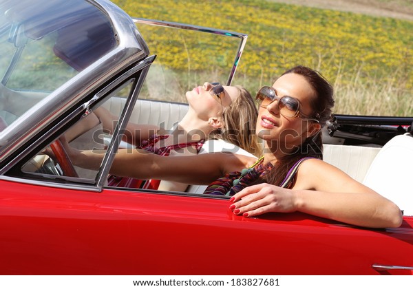Beautiful
women driving a red car wearing
accesoriess