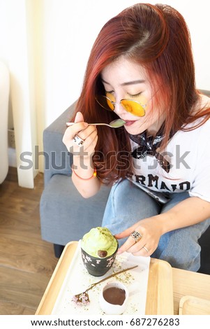 Beautiful women eat green tea ice-cream at Cafe.