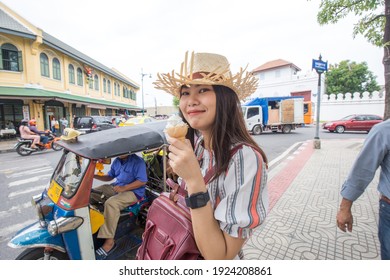 Beautiful women eat ice cream while travel in urban city lifestyle walking on downtown street of Bangkok City, Thailand, Concept Travel