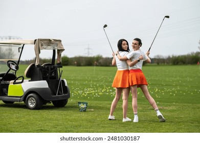 Beautiful women golfers standing by the golf cart on the green lawn - Powered by Shutterstock