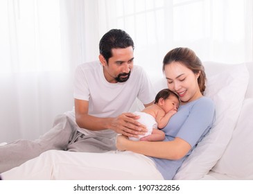 Beautiful Women Married Man With Beard Hispanic Mix Race, Husband Hold And Looking Wife And Baby Infant With Love, Mother Embrace Newborn Son Softly Caring And Protection On Bed, Happy Family Concept