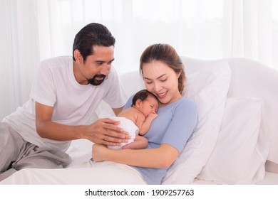 Beautiful Women Married Man With Beard Hispanic Mix Race, Husband Hold And Looking Wife And Baby Infant With Love, Mother Embrace Newborn Son Softly Caring And Protection On Bed, Happy Family Concept