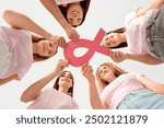 Beautiful women with pink ribbon on color background, bottom view. Breast cancer awareness concept