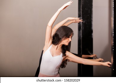 Beautiful women practicing ballet in a barre at a dance academy