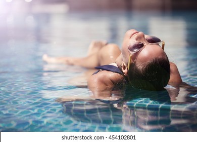 Beautiful Women Relaxing At The Luxury Poolside. Girl At Travel Spa Resort Pool. Summer Luxury Vacation.