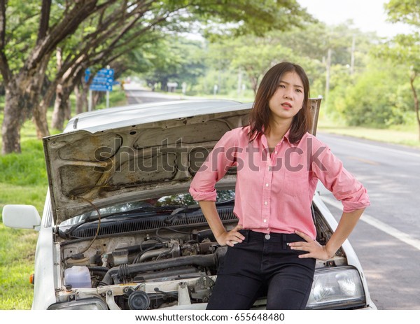 Beautiful women sad and waiting\
for help. The old car have a engine break down on the local\
road.